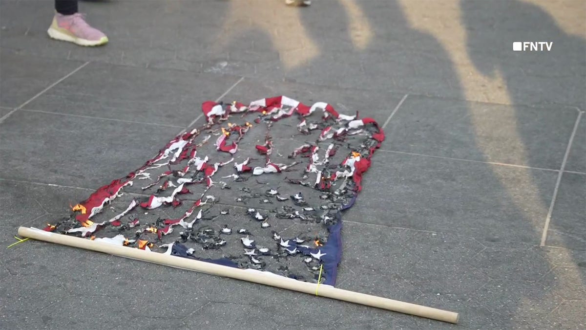 A burned American flag on the ground