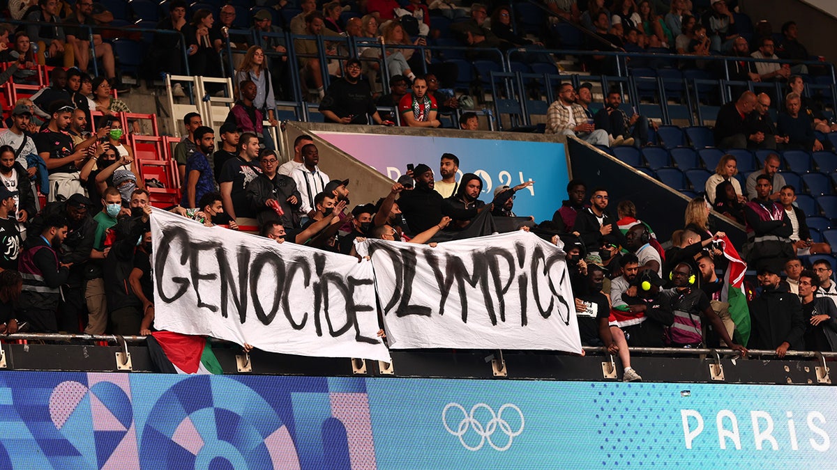 Anti-Israel protesters hold a sign reading 'Genocide Olympics'