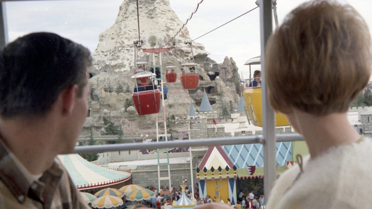 A couple rides the gondola toward the Matterhorn at Disneyland.