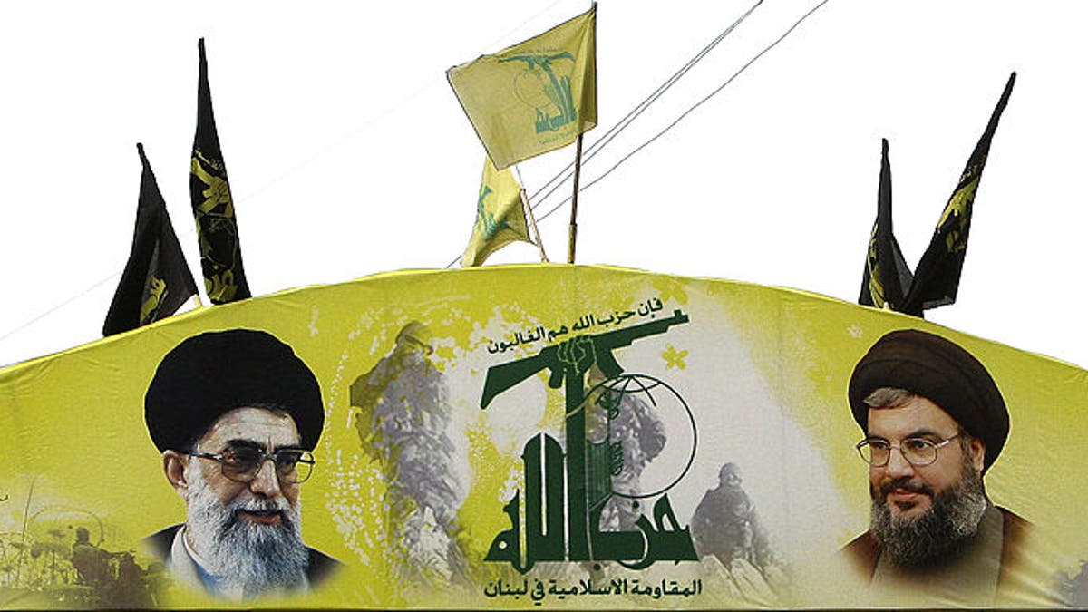 An arch glorifying Hezbollah and baring pictures of its chief Hassan Nasrallah, right, and Iran's spiritual leader Ali Khamenei decorates a street of Beirut's southern suburb on Jan. 16, 2011.