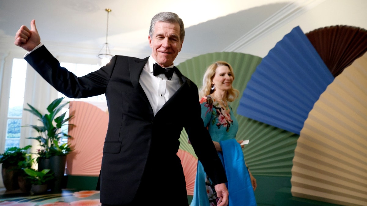 Roy Cooper, governor of North Carolina, left, and Kristin Cooper, right, arrive to attend a state dinner in honor of Japanese Prime Minister Fumio Kishida hosted by US President Joe Biden and First Lady Jill Biden at the White House in Washington, DC, US, on Wednesday, April 10, 2024. 