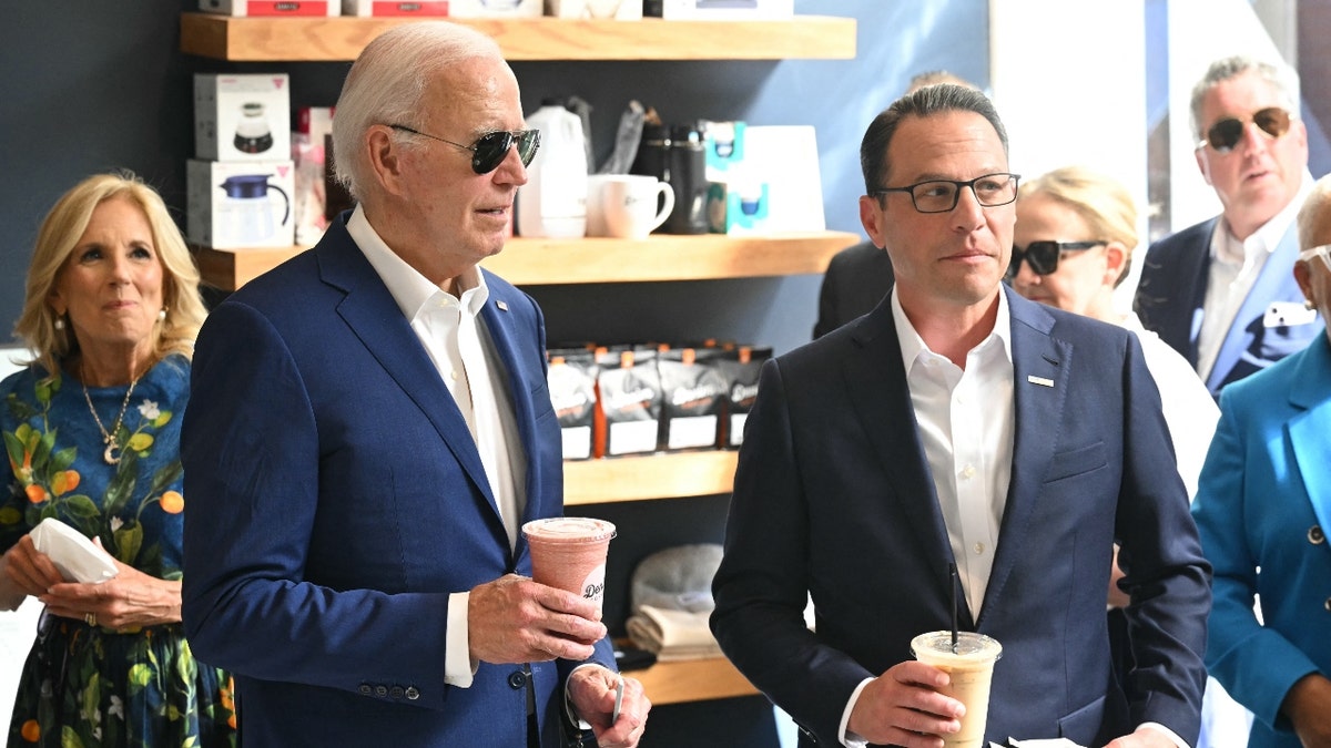 US President Joe Biden, First Lady Jill Biden (L) and Pennsylvania Governor Josh Shapiro (R) visit a coffee shop in Harrisburg, Pennsylvania,