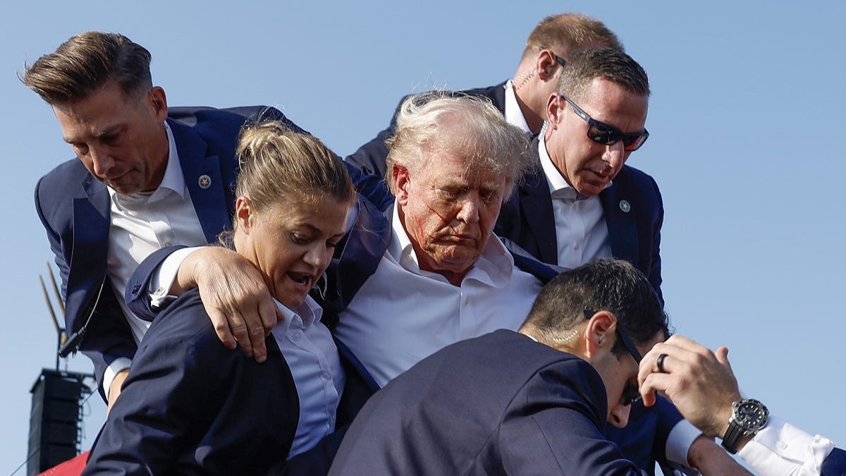 Donald Trump is rushed offstage by U.S. Secret Service agents after being grazed by a bullet during a rally on July 13, 2024 in Butler, Pennsylvania.