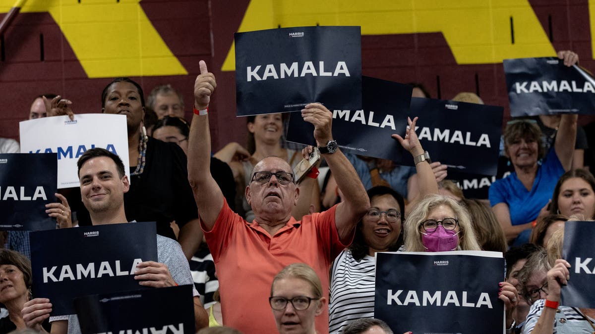 supporters holding Kamala signs in rally