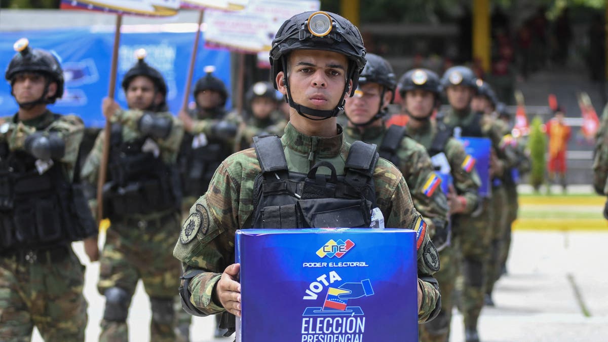 An army soldier holds a ballot box as he takes part in a military parade displaying electoral material to be used in the upcoming presidential elections at Fuerte Tiuna in Caracas on July 24, 2024.?