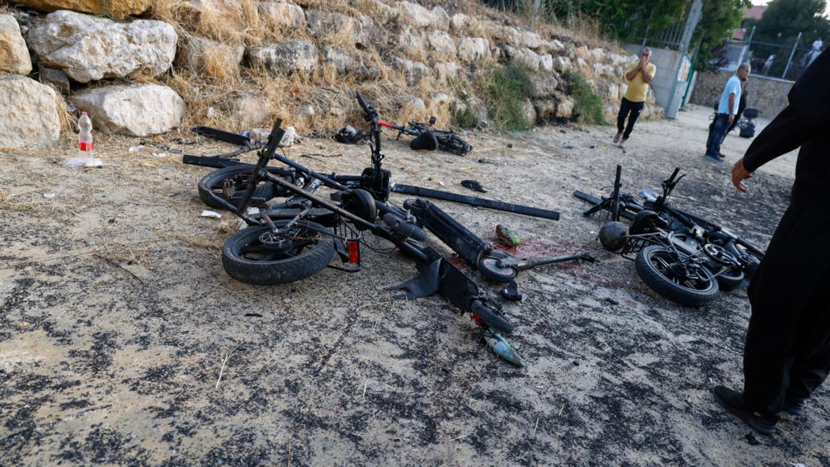 People stand by damaged bicycles at a site where a reported strike from Lebanon fell in Majdal Shams village in Israel on July 27, 2024.