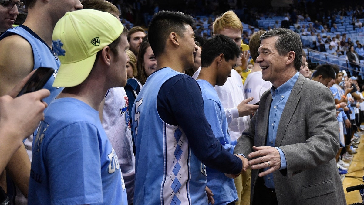 Roy Cooper greets Tar Heels fans at a basketball game
