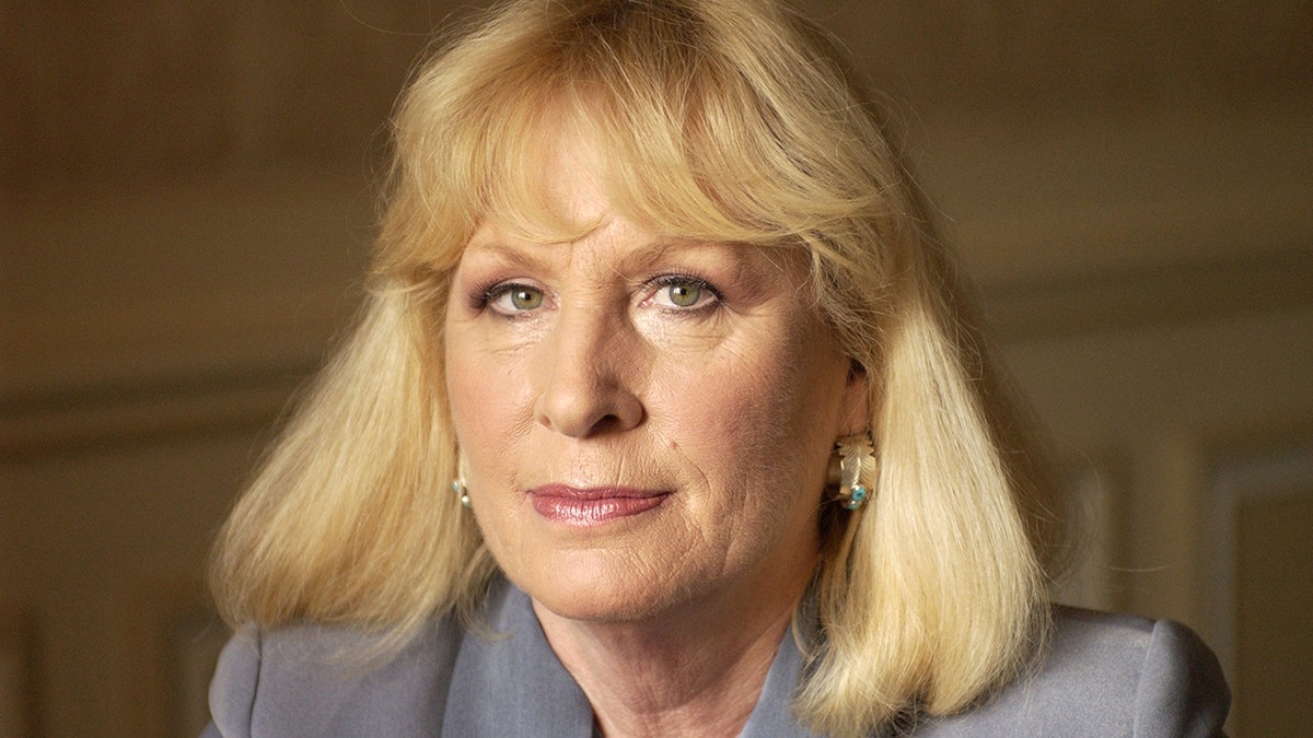 A close-up of Christina Crawford in a grey suit.