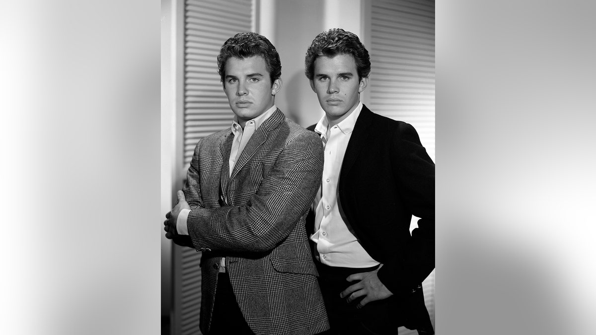 Dack Rambo posing with his twin brother in a black and white photo.