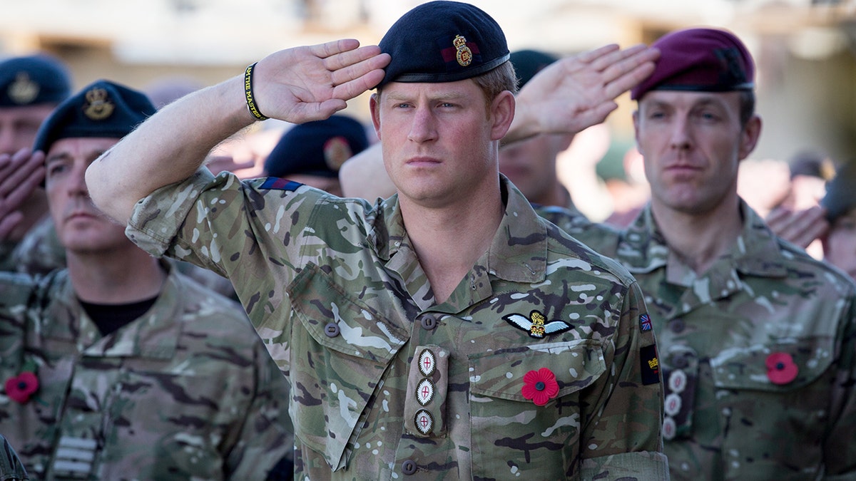 Prince Harry saluting in military gear.