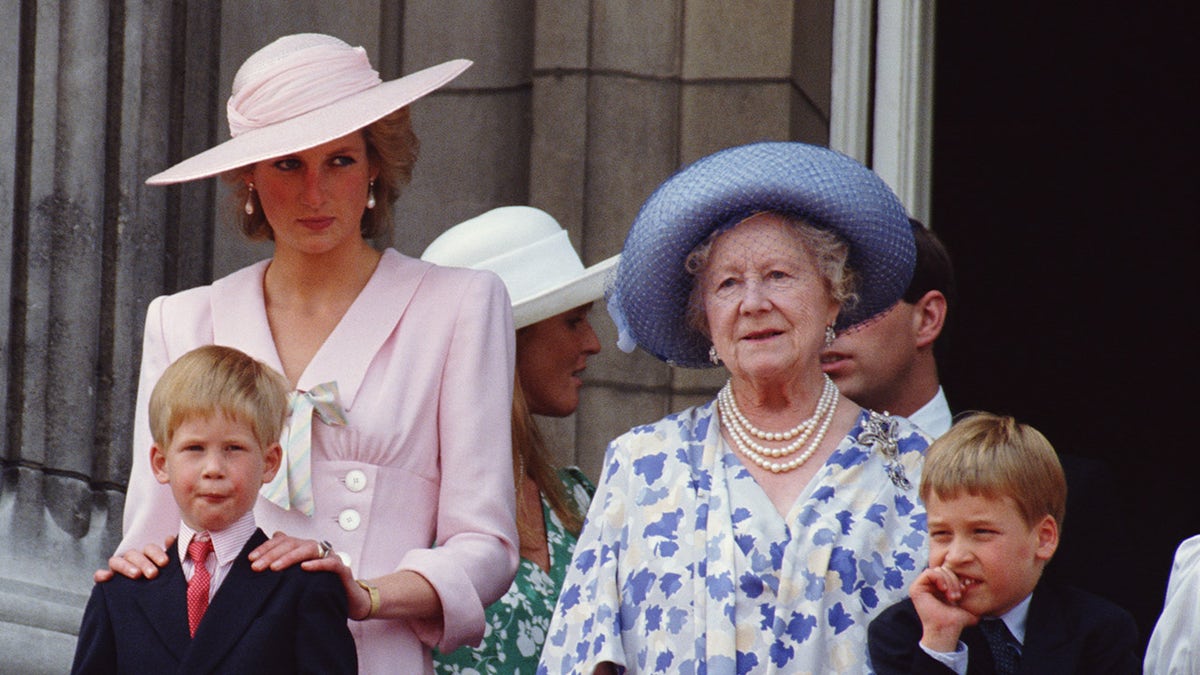 Princess Diana resting her shoulders on a young Prince Harry as she watches the Queen Mother stand to a young Prince William.