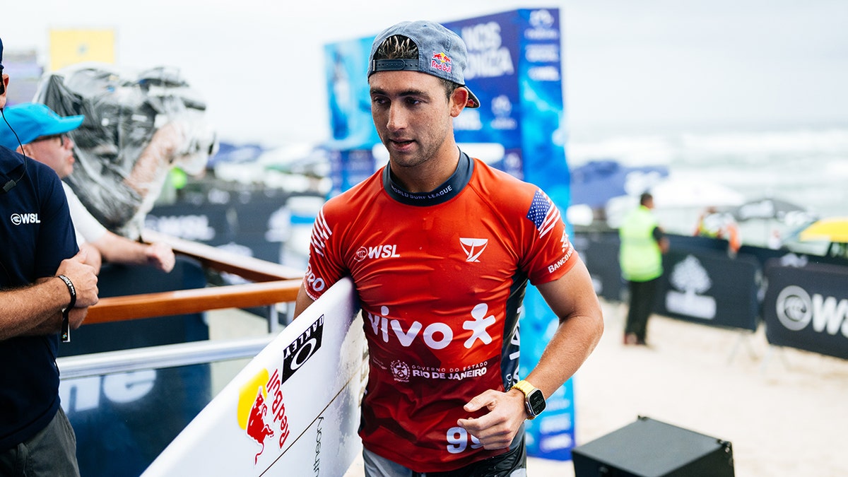 Griffin Colapinto walks with a surfboard