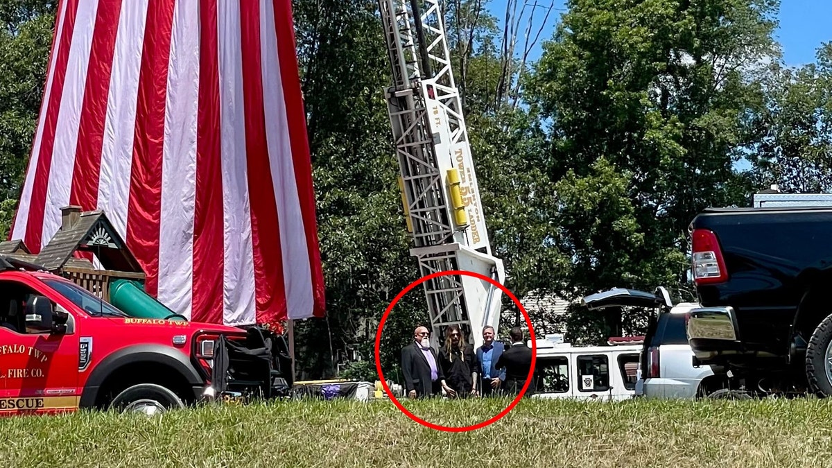 A photo of Billy Ray Cyrus standing with law enforcement outside Corey Comperatore's funeral