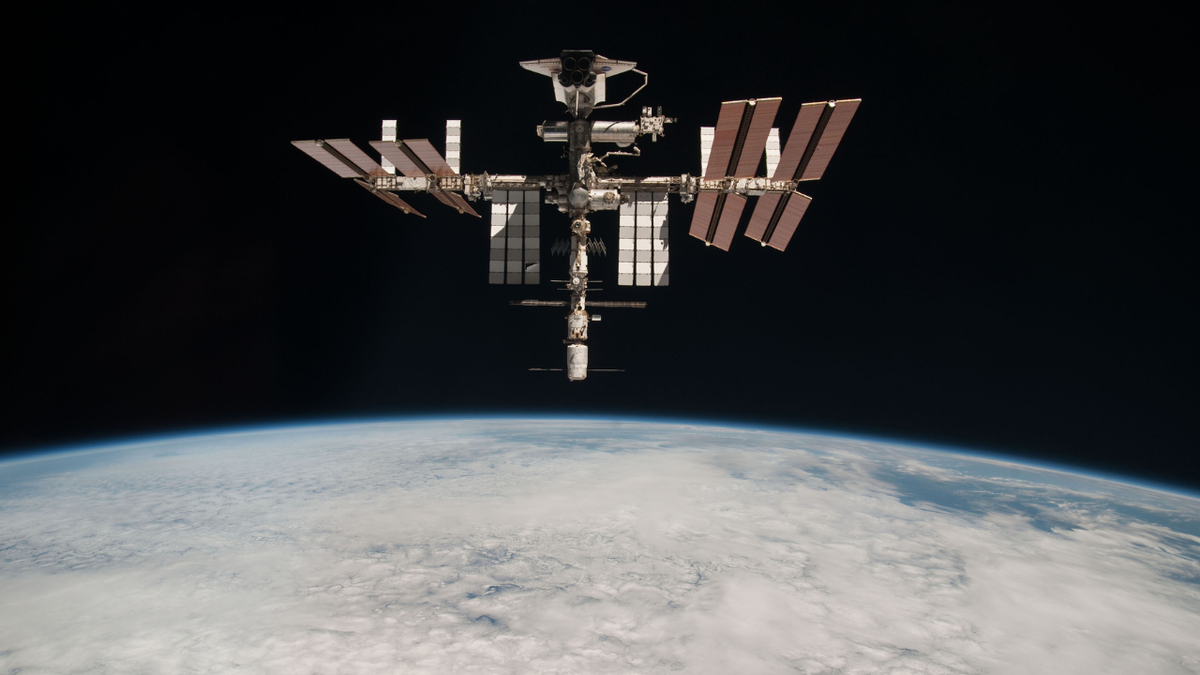 Se ve la Estación Espacial Internacional con la Tierra al fondo