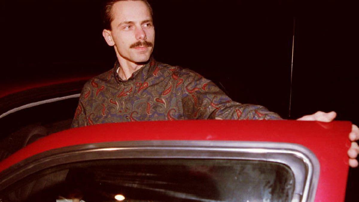 Jeff Gillooly posing next to a car