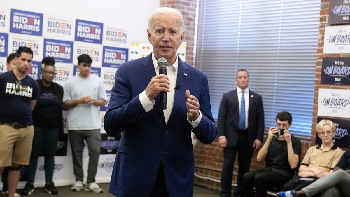 Biden holding microphone, speaking to campaign volunteers