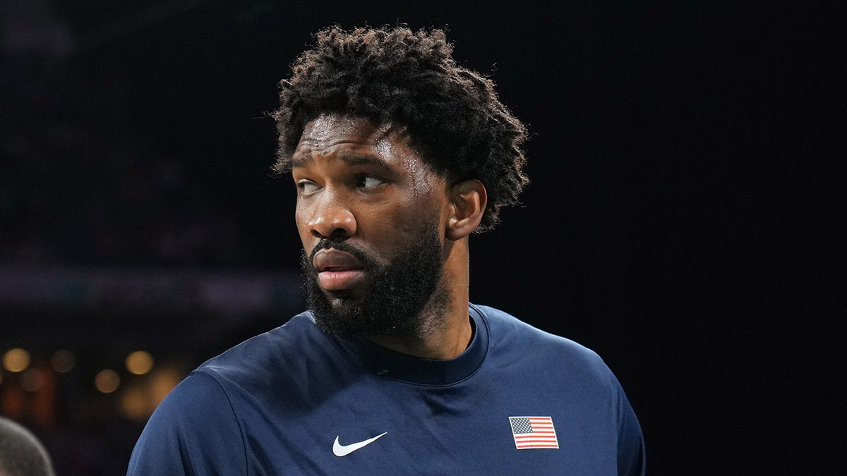 Joel Embiid se vira para olhar para a quadra