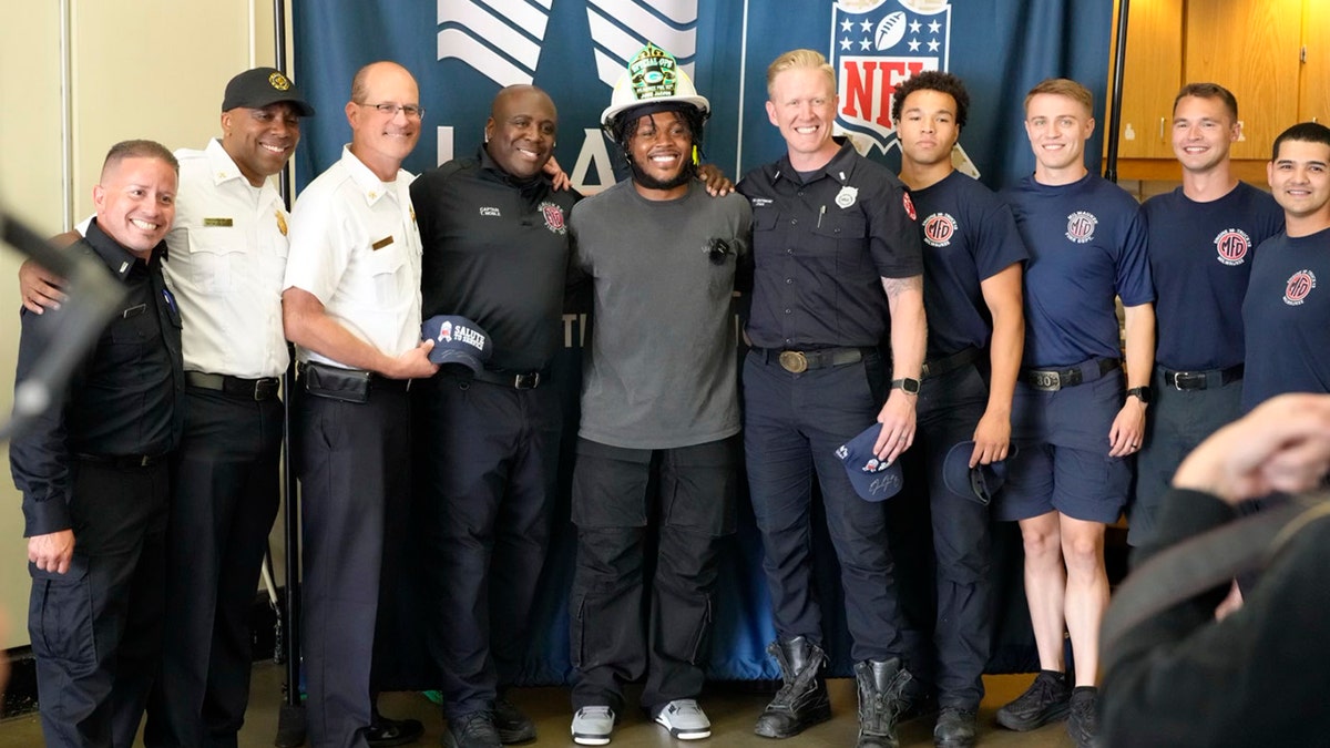 Josh Jacobs takes picture with Milwaukee Fire Department members