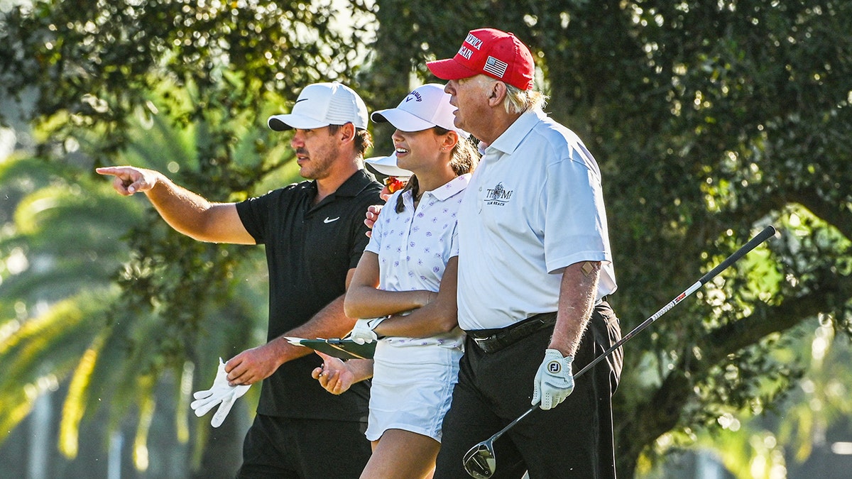 Former President Donald Trump, U.S. golfer Brooks Koepka, and Kai Trump play golf at Trump National Doral Miami golf club on October 27, 2022, in Miami, Florida.