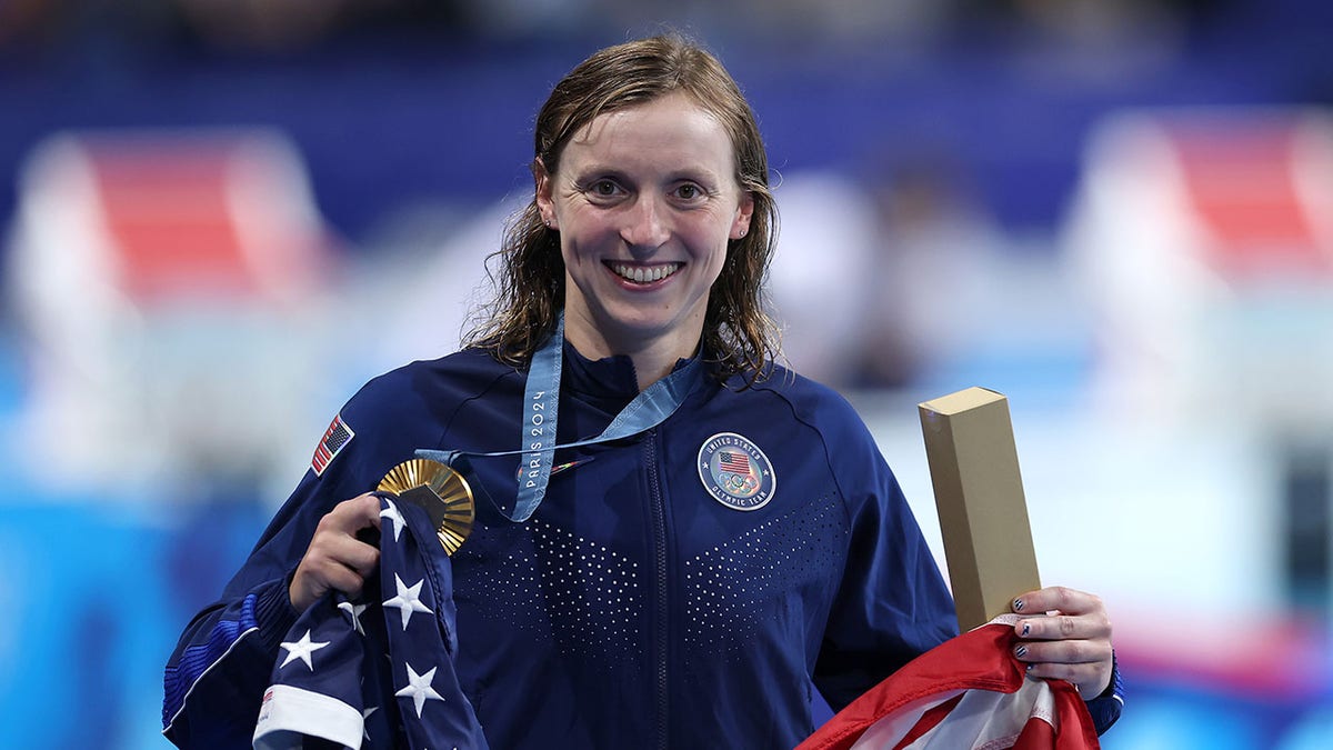 Katie Ledecky sonríe con la bandera