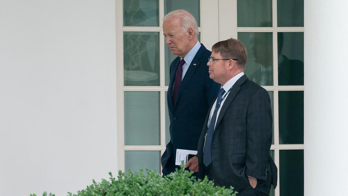 Biden and Dr. O'Connor walk along the side of the White House