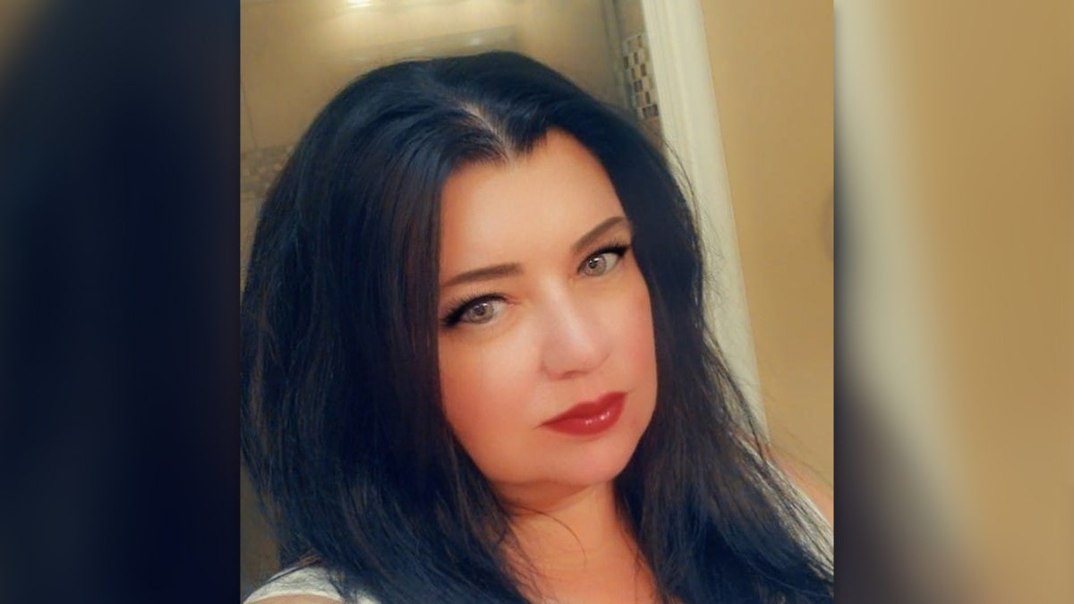Kristie Thibodeaux in a selfie photo, with black hair and red lipstick