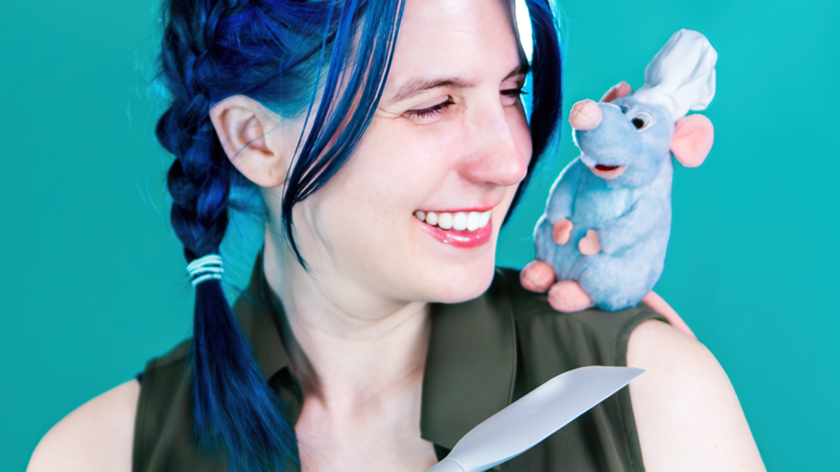 Woman with blue hair in pigtails with tiny Remy stuffed animal.