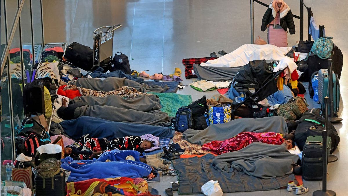 Migrants sleep on the floor at Logan Airport