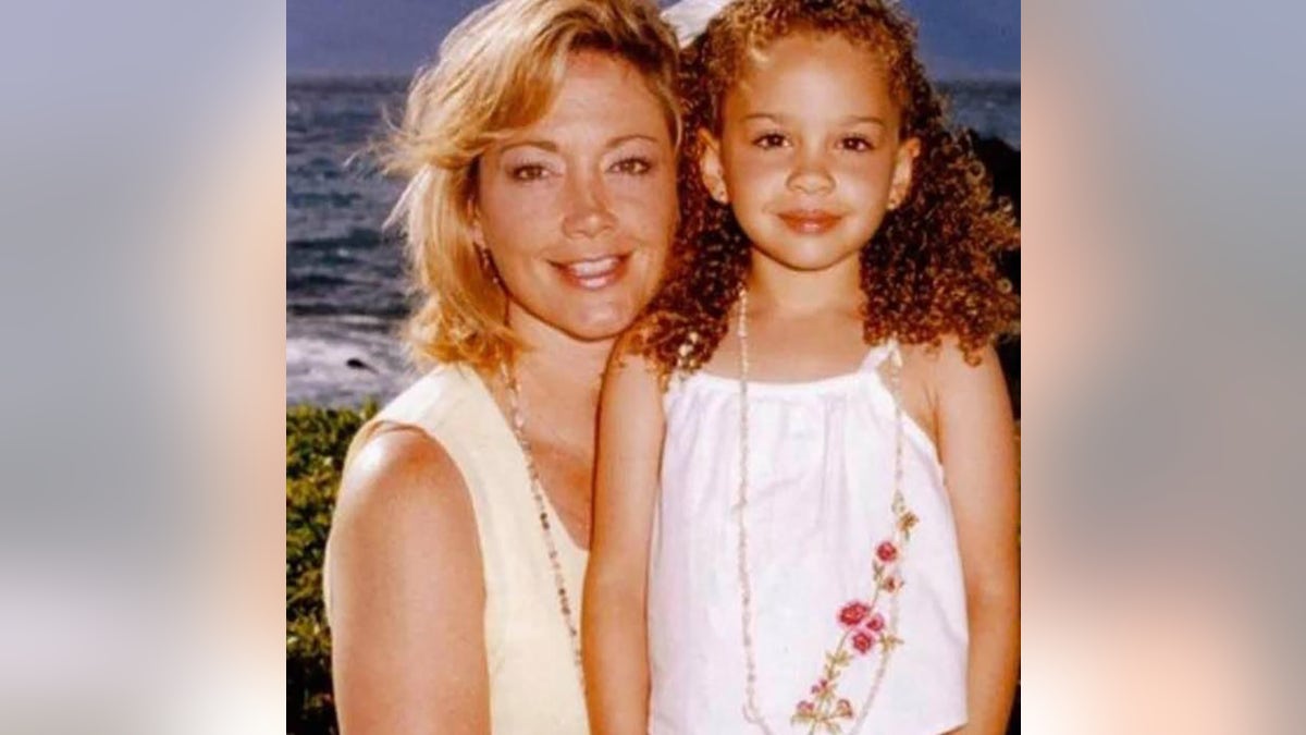 Madison McGhee cuando era niña posando con su madre en la playa.