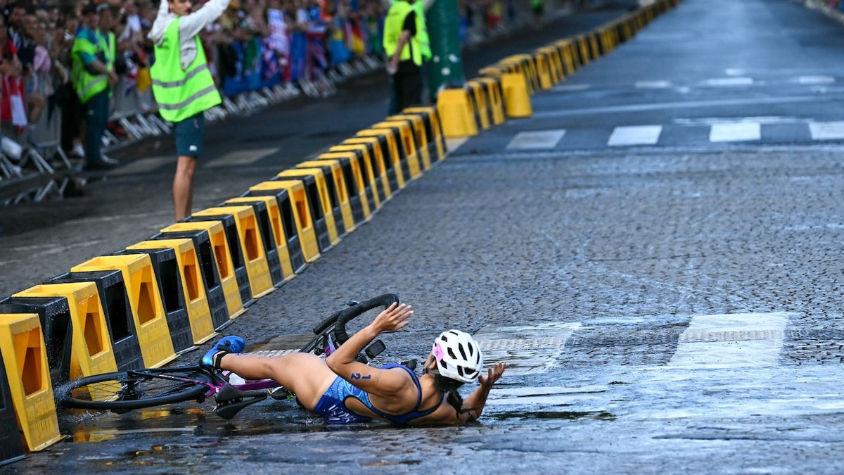 Guam's Manami Iijima crahses as she competes in the cycling race during the women's individual triathlon at the Paris 2024 Olympic Games in central Paris on July 31, 2024. (Photo by Ben STANSALL / AFP)
