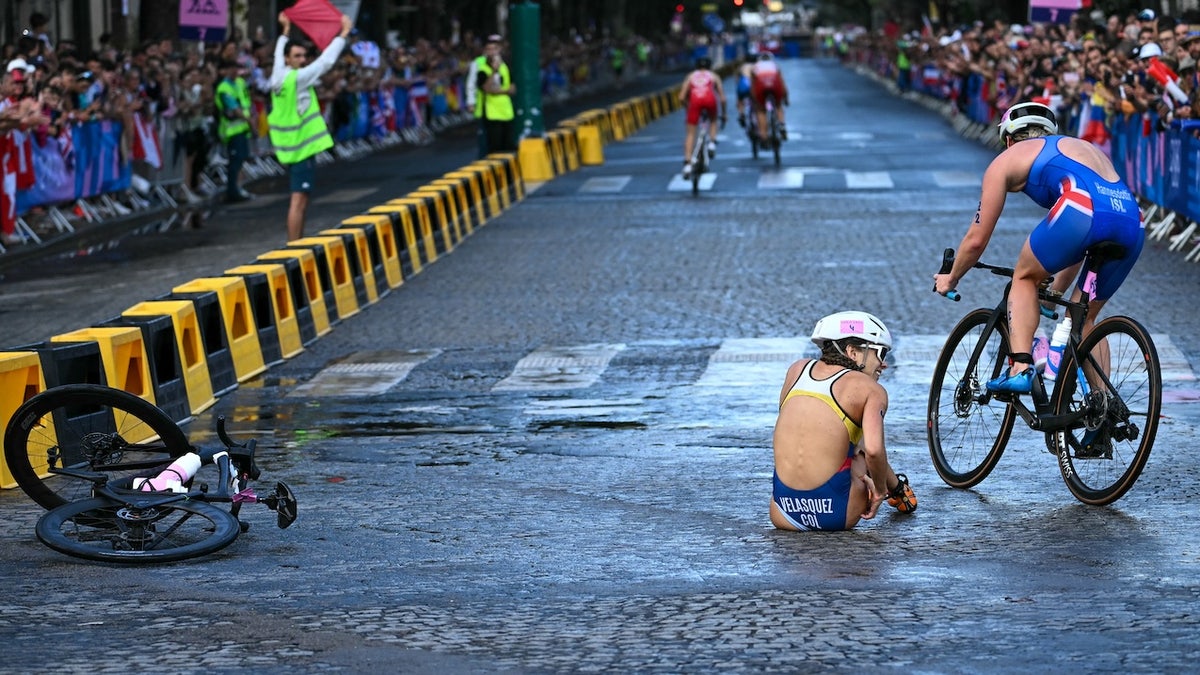 Colombia's Maria Carolina Velasquez Soto falls on the ground as she competes in the cycling race during the women's individual triathlon at the Paris 2024 Olympic Games in central Paris on July 31, 2024. (Photo by Ben STANSALL / AFP)