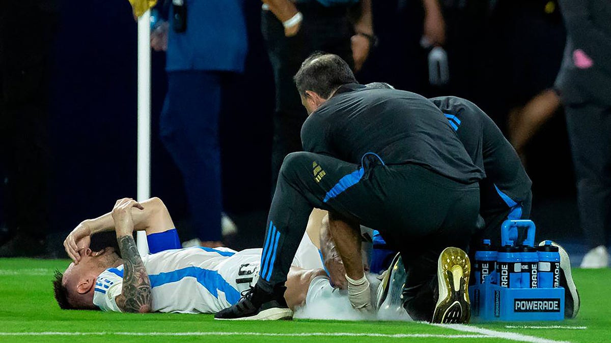 Lionel Messi being tended to by trainers