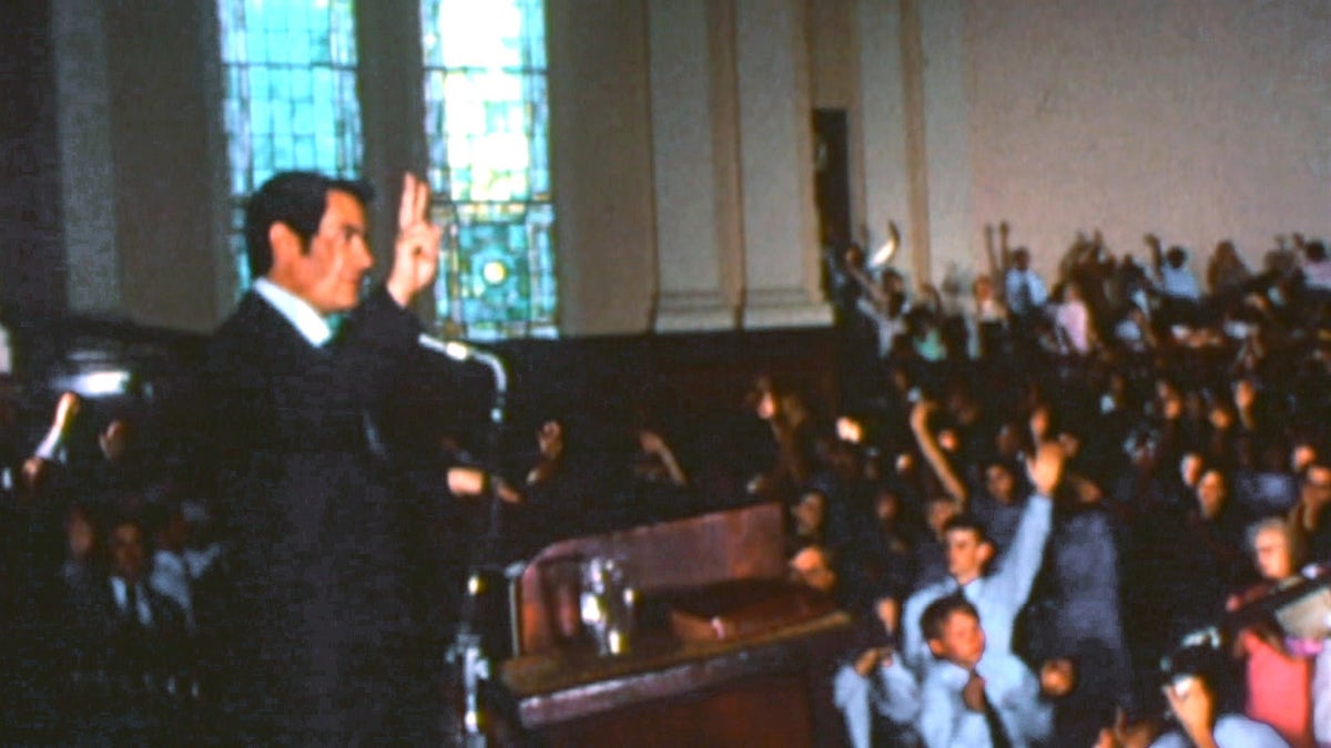 Jim Jones preaching to a group of people in the Peoples Temple.