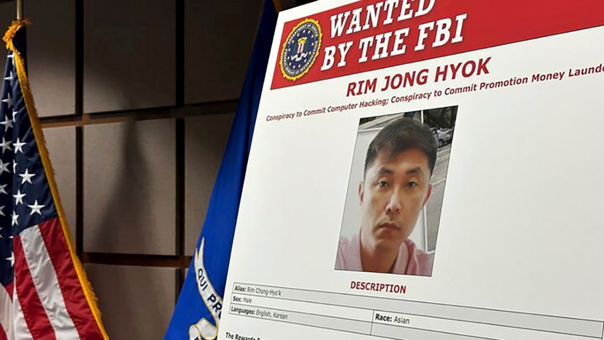 A poster board reading "wanted by the FBI" shows North Korean hacker Rim Jong Hyok.