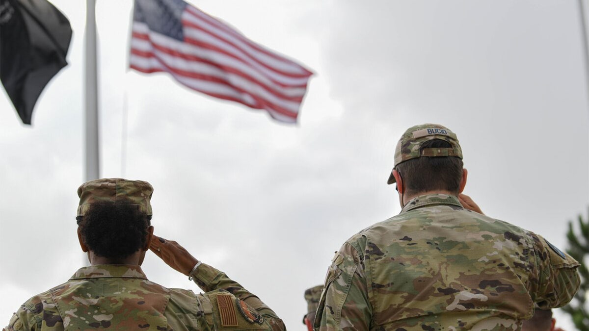 Miembros de la Guardia Nacional saludan a la bandera estadounidense