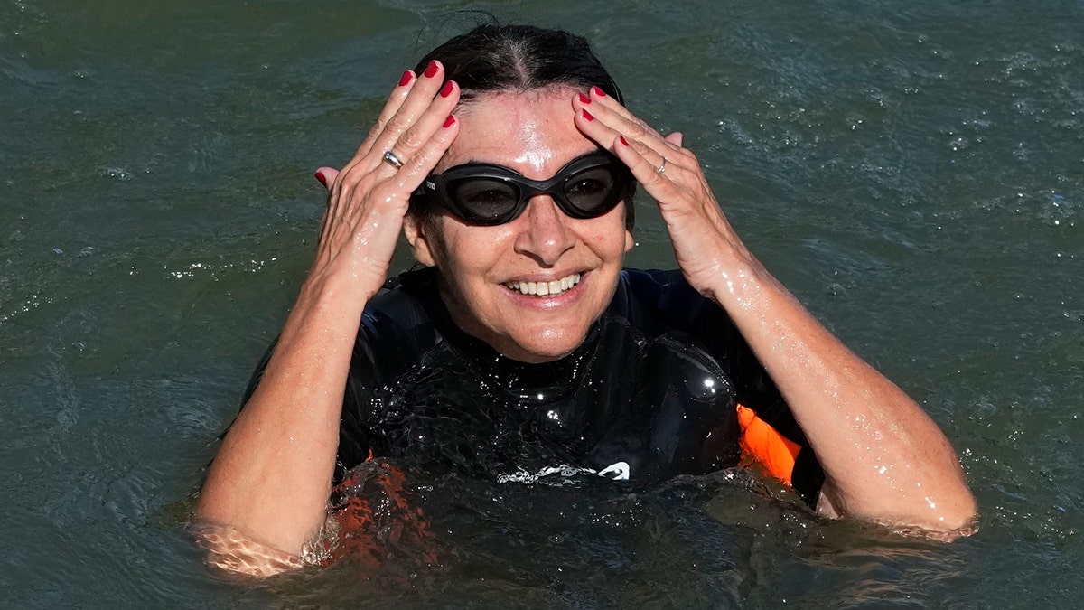 Paris Mayor Anne Hidalgo treads water in the Seine River.