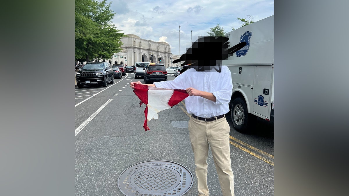 Un patriota anónimo sostiene un fragmento de la bandera estadounidense que salvó de los agitadores
