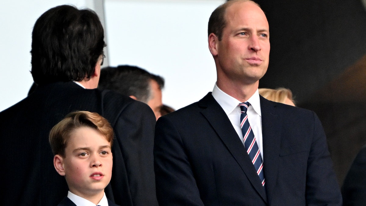 Prince William and son Prince George wore matching dark suits for the game.