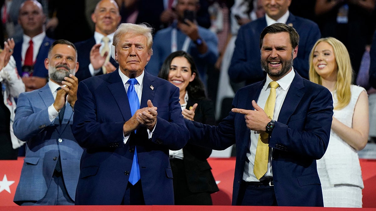 Donald Trump applauds as Republican vice presidential nominee J.D. Vance gestures on Day 2 of the Republican National Convention