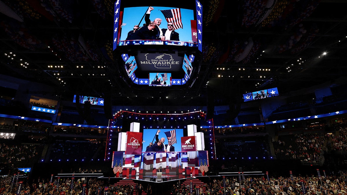 Donald Trump, Jr. speaks as an image taken by photographer Evan Vucci following the assassination attempt on Republican presidential nominee and former U.S. President Donald Trump is shown on a large screen on Day 3 of the Republican National Convention