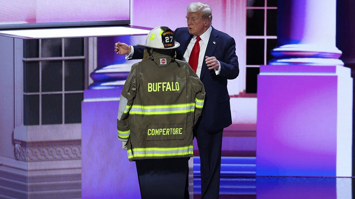 Donald Trump embraces the turnout coat and helmet of former Buffalo Township Volunteer Fire Department chief Corey Comperatore