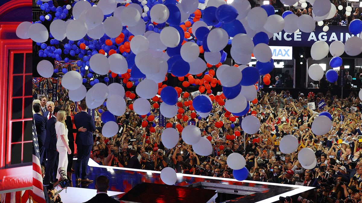 Republican presidential candidate and the family of former US President Donald Trump join him on stage as balloons fall after his speech on the fourth day of the Republican National Convention.