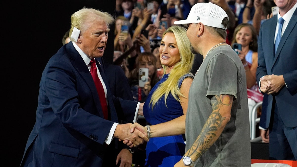 Donald Trump greets country music singer Jason Aldean as he arrives for the final day of the Republican National Convention