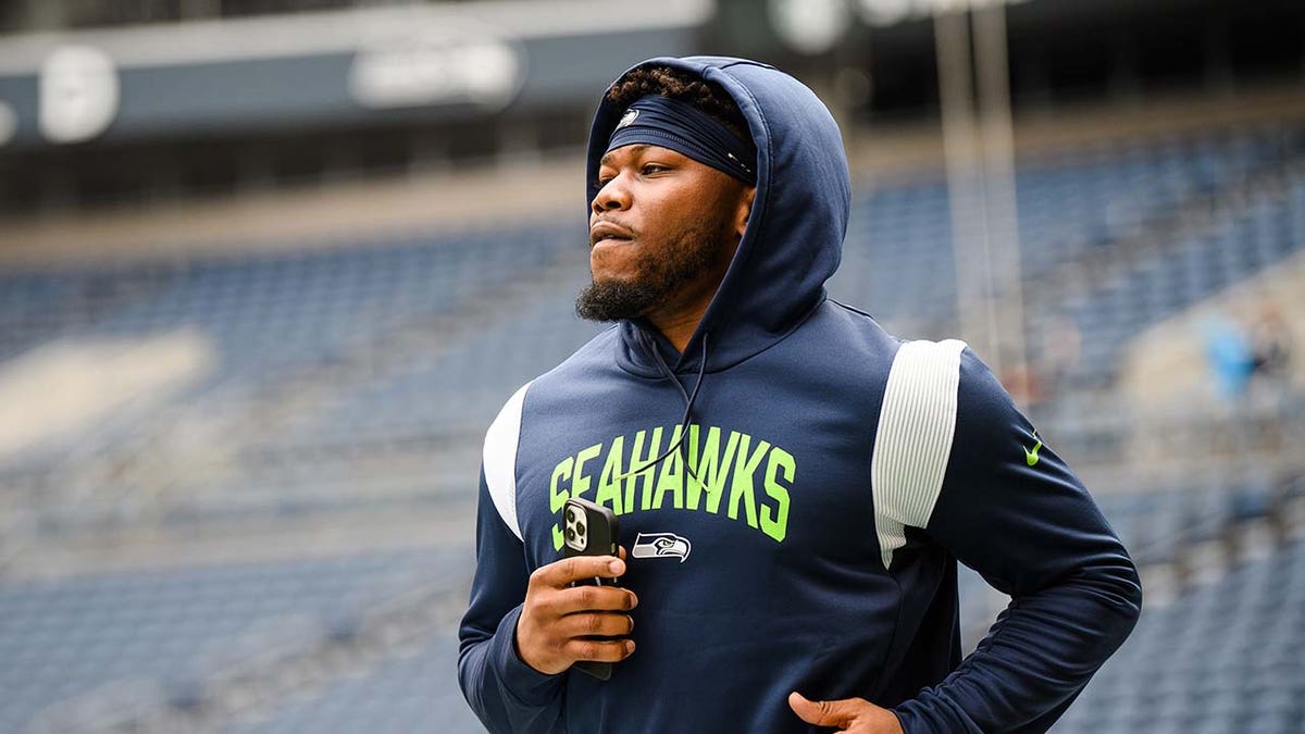 Rashaad Penny warms up before a game