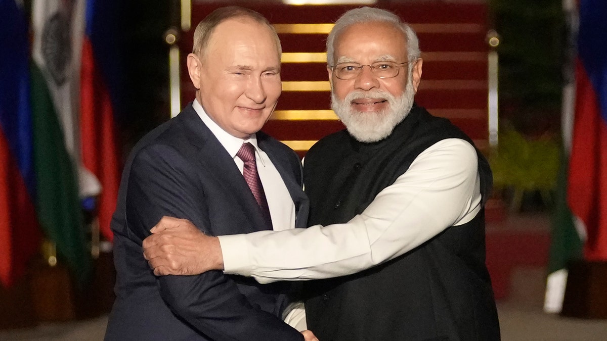 El presidente ruso Putin y el primer ministro indio Modi se estrechan la mano.