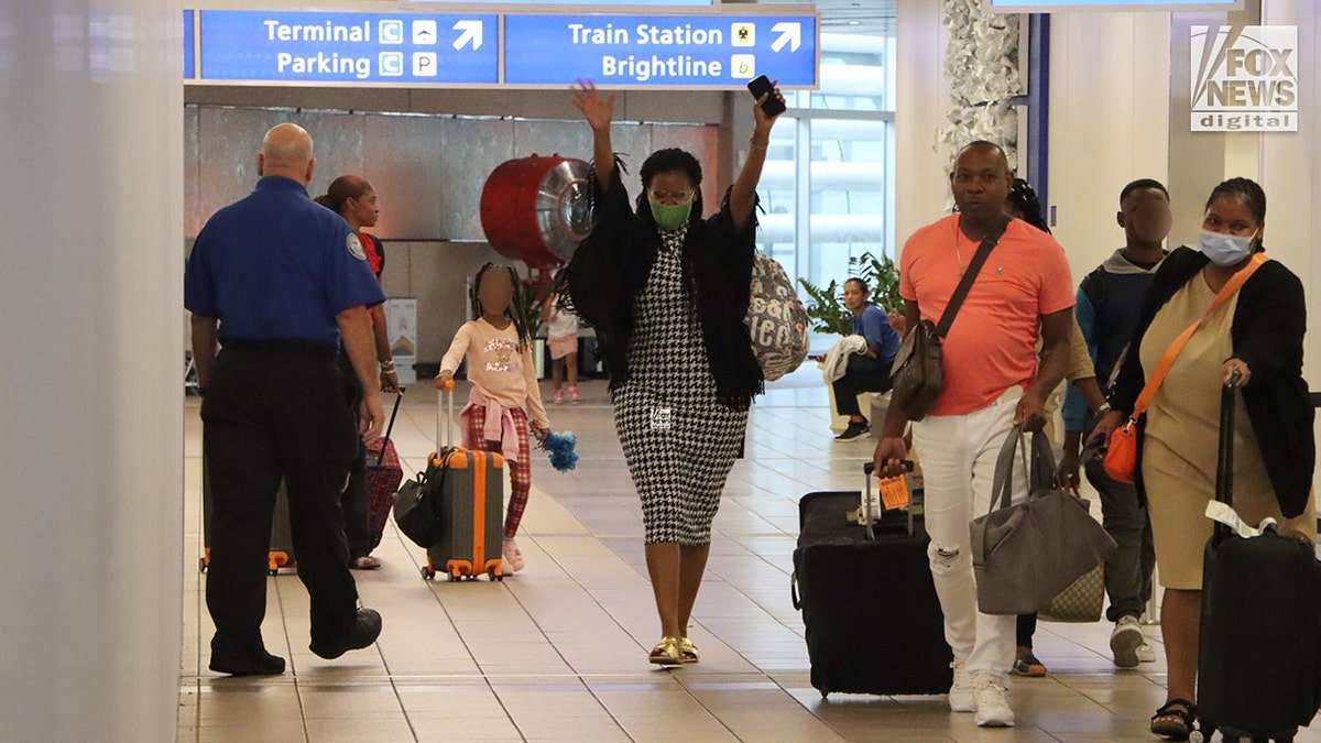 Sharitta Grier camina por el aeropuerto con los brazos en alto