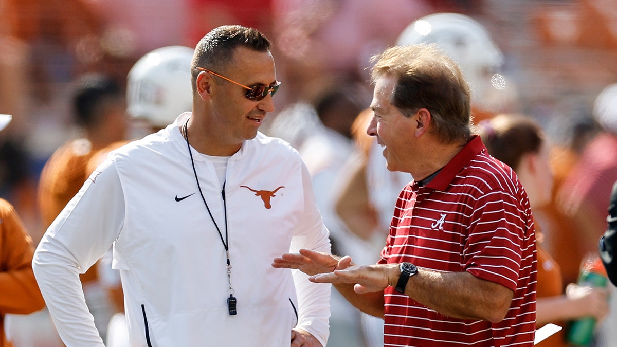 Steve Sarkisian y Nick Saban hablan