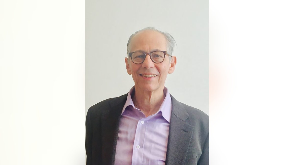 Steve Fishman in a gray blazer and purple blouse.