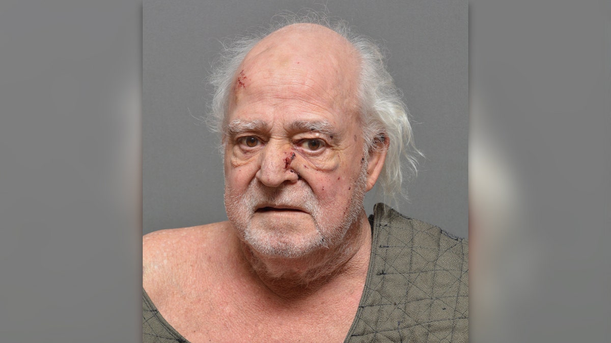 Steven Schwally has cuts on his nose and balding forehead while wearing a protective vest in his Suffolk County mugshot