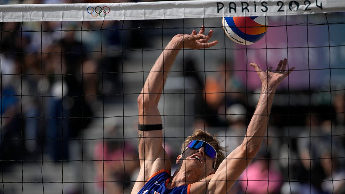 Dutch Olympic beach volleyball player, who was convicted of raping young girl, faces boos before match 4 Steven van de Velde by the net